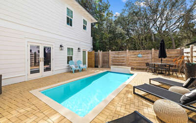 Your private backyard oasis awaits with a sparkling pool, comfortable lounge chairs, and dining area perfect for sunny afternoons and evening barbecues.