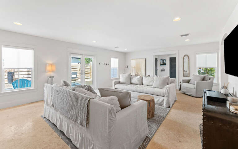 Relax in your bright, spacious living room with plush seating and coastal views through large windows.