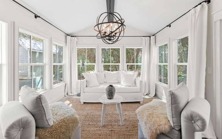 Step into your bright sunroom sanctuary, where plush seating and panoramic windows create the perfect spot for morning coffee or evening relaxation.
