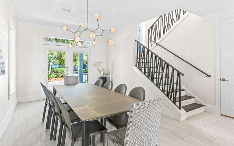 Gather around your sleek dining table for memorable meals under elegant statement lighting, with garden views beckoning beyond.