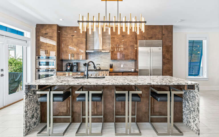 Gather around this stunning granite island where warm wood meets modern design, perfect for your morning coffee or evening conversations.