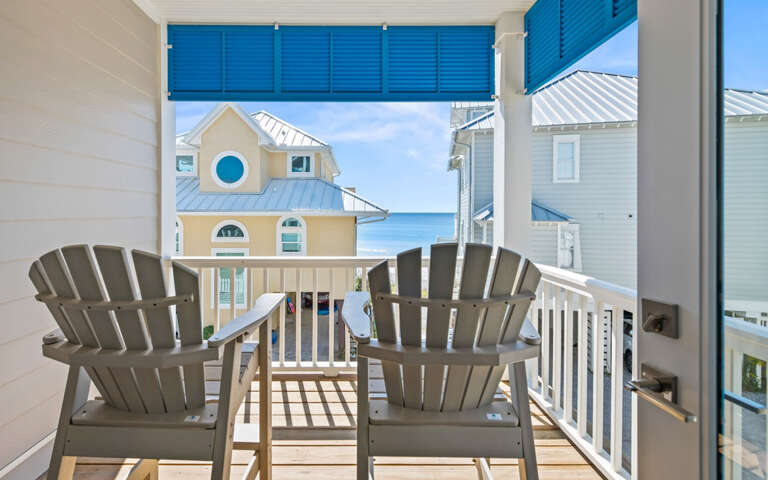 Step onto your private balcony and sink into comfortable Adirondack chairs while taking in colorful beach house views and glimpses of blue ocean beyond.