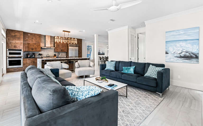 Unwind in your spacious living area with plush seating and a gourmet kitchen featuring warm wood cabinetry and premium appliances.