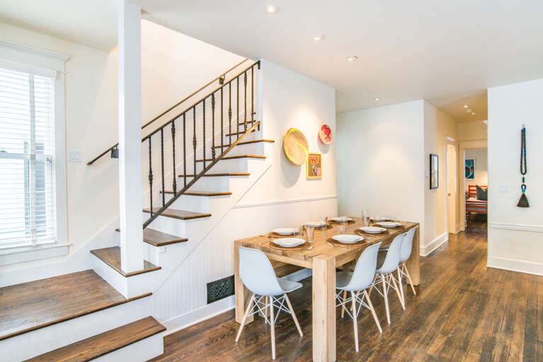 Dining area seats 8 people with bench on the other side of the table. The floors are the original 1899 wood floors.