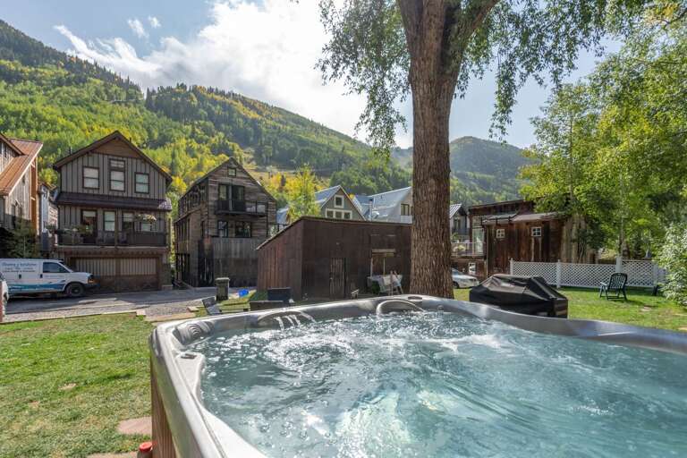 Enjoy the large back lawn with hot tub, table, chairs and grill.