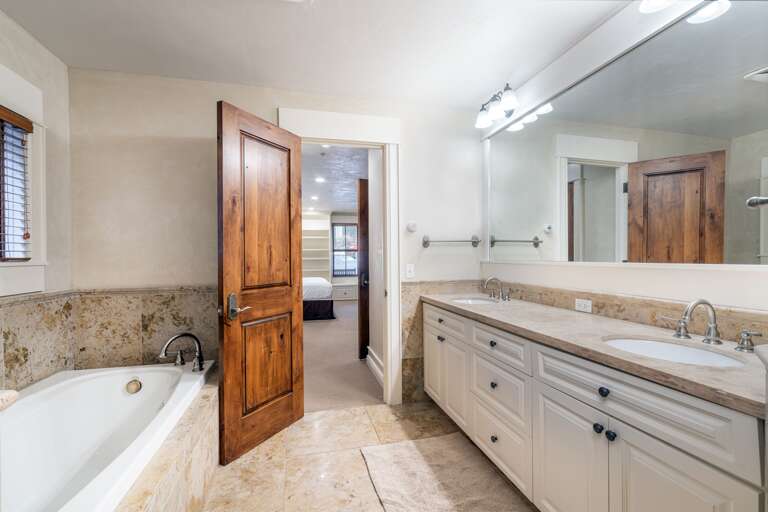 Master bathroom with double vanity, separate bath tub and steam shower.