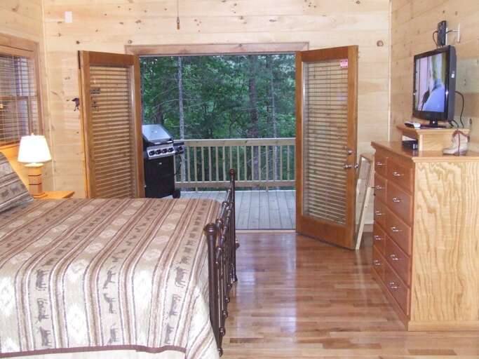 The bedroom on the Main Floor offers a King Size bed with access to the covered fromt porch.