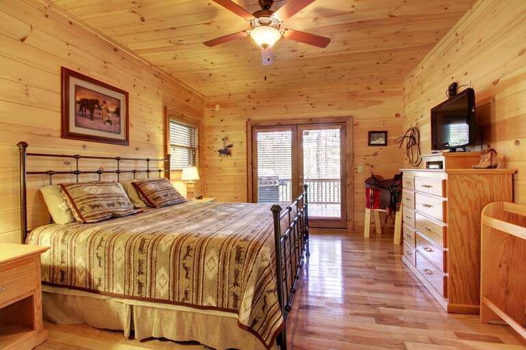 KING BED LOCATED IN THE MAIN LEVEL BEDROOM which has access to the outside deck