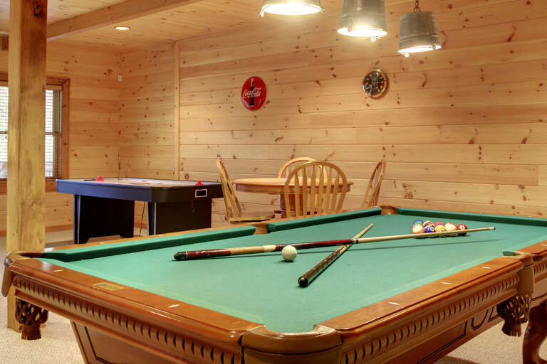 Located in the lower level of the cabin is the game room. Relax around the gas log fireplace or enjoy a game of pool, air hockey or a competitive game of darts