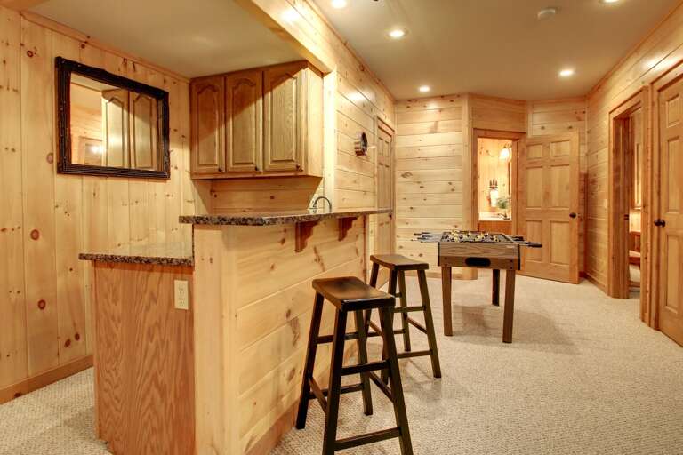 The family/gam room has a wet bar with stool seating.