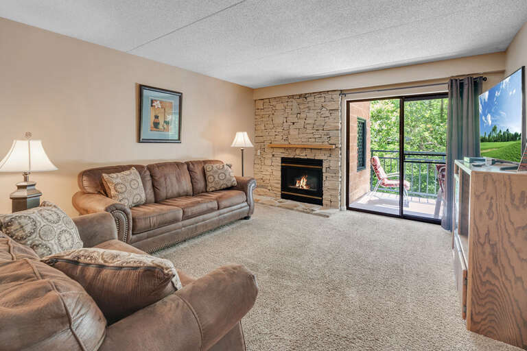 Living Room With Sofas, Fireplace, And Open Balcony Door Living Room With Sofas, Fireplace, And Open Balcony Door
