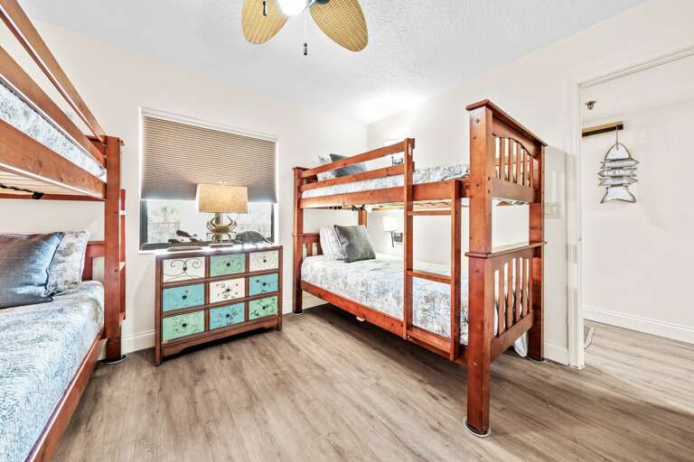 The third bedroom is furnished with two twin bunk beds, accommodating up to four guests. Reading lights and charging outlets are mounted by each bed