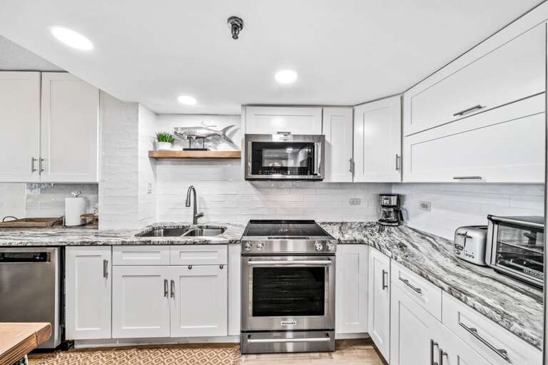 Experience the beauty of the stunning, modern kitchen, complete with sleek stainless steel appliances and everything you need for a seamless cooking experience