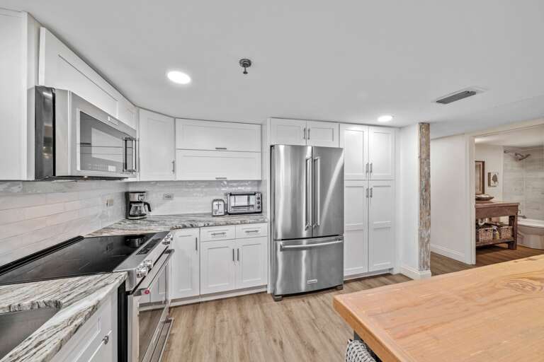 Prepare meals with ease in the kitchen, featuring sleek stainless steel appliances that combine functionality and style