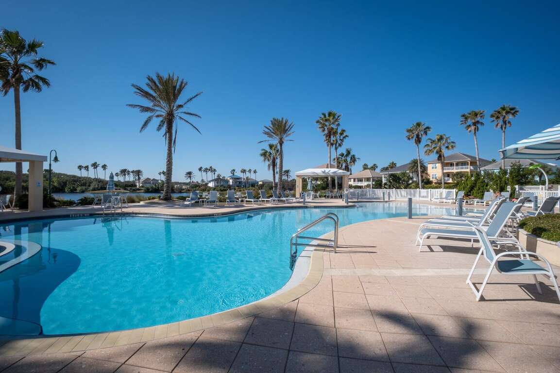 Pool deck with chairs, tables, and a sparkling swimming pool Pool deck with chairs, tables, and a sparkling swimming pool
