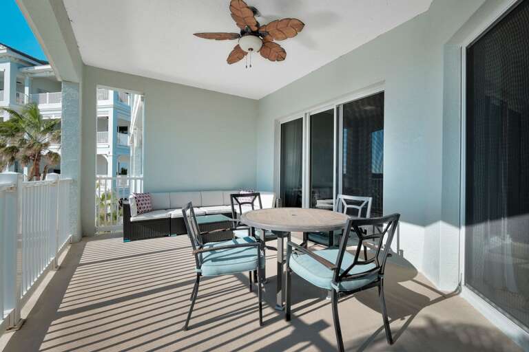 Spacious balcony featuring a table, chairs, and a comfortable couch Spacious balcony featuring a table, chairs, and a comfortable couch