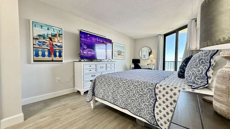 Bedroom retreat featuring a king bed, TV, ocean view, and direct balcony access for ultimate relaxation Bedroom retreat featuring a king bed, TV, ocean view, and direct balcony access for ultimate relaxation