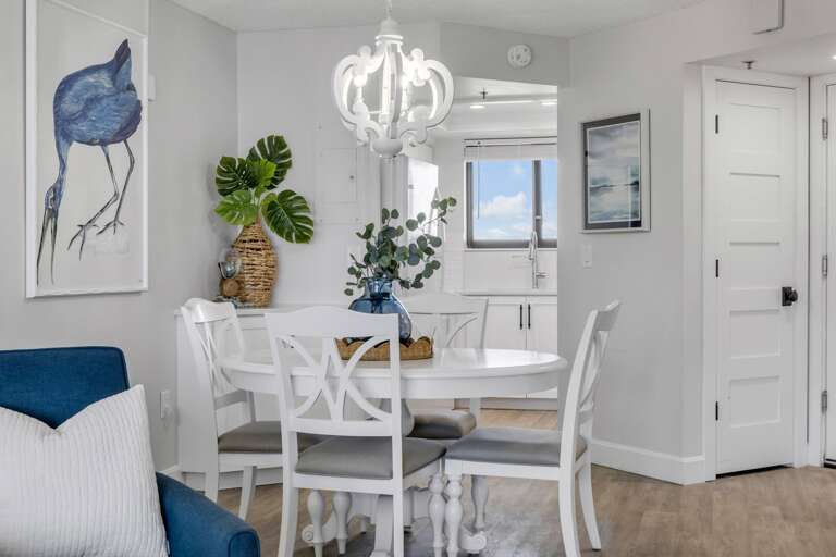 Bright dining area with natural light from large sliding glass doors, offering a view of New Smyrna Beach