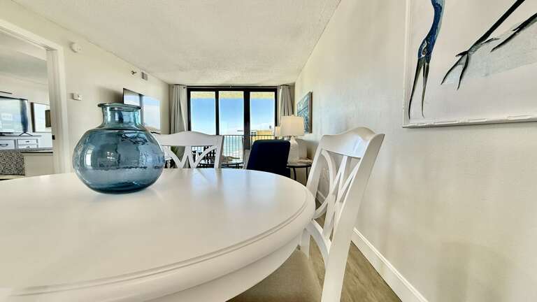 Bright dining area with natural light from large sliding glass doors, offering a view of New Smyrna Beach Bright dining area with natural light from large sliding glass doors, offering a view of New Smyrna Beach