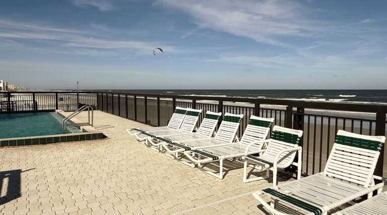 Chairs on the beachfront pool deck, perfect for soaking up the sun while listening to the soothing ocean waves