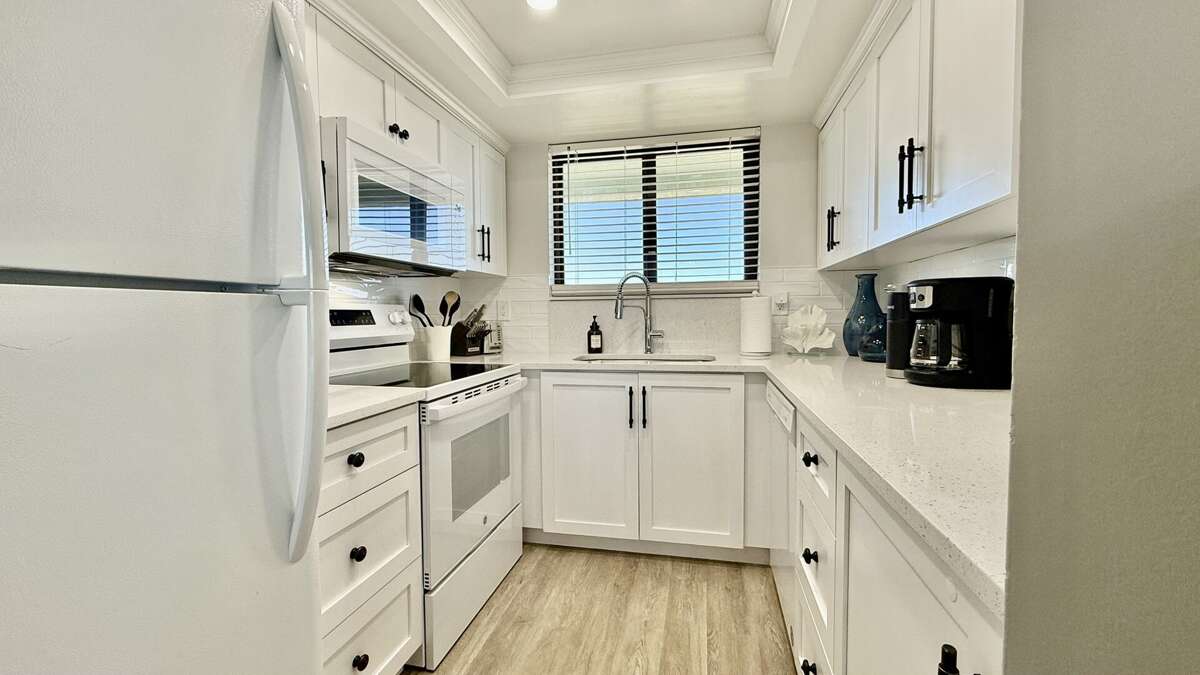 Renovated kitchen with fresh white appliances, cabinets, and countertops—fully equipped for your beach getaway Renovated kitchen with fresh white appliances, cabinets, and countertops—fully equipped for your beach getaway