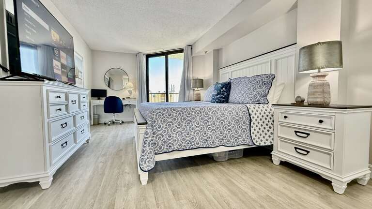 The spacious bedroom features a king bed, large smart TV, and direct access to the balcony The spacious bedroom features a king bed, large smart TV, and direct access to the balcony
