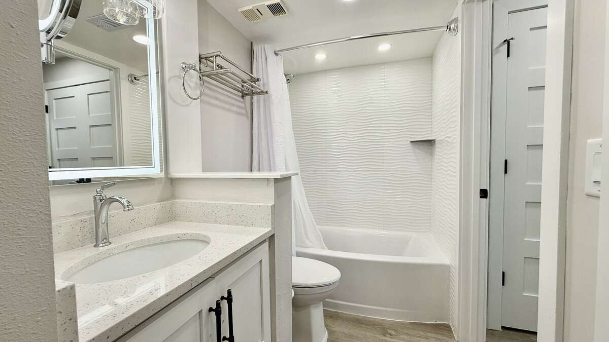 Updated bathroom featuring a renovated tile tub/shower combo for a fresh, modern feel Updated bathroom featuring a renovated tile tub/shower combo for a fresh, modern feel