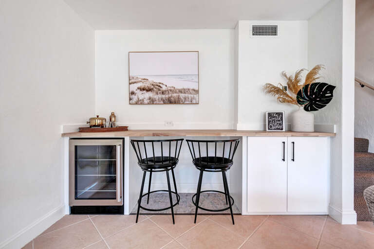 Enjoy bonus seating with two barstools and a wine fridge just off the living room - perfect for casual gatherings and unwinding.