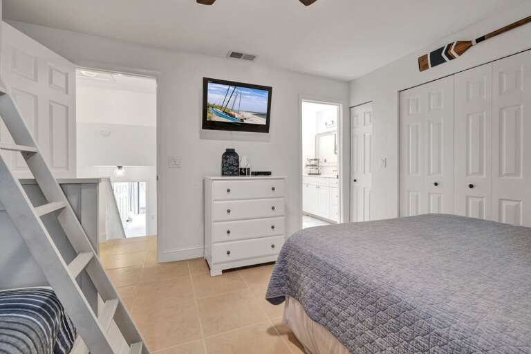Relax after a day at the beach in the guest bedroom, complete with a queen bed, twin over full bunk bed, and a TV for entertainment.
