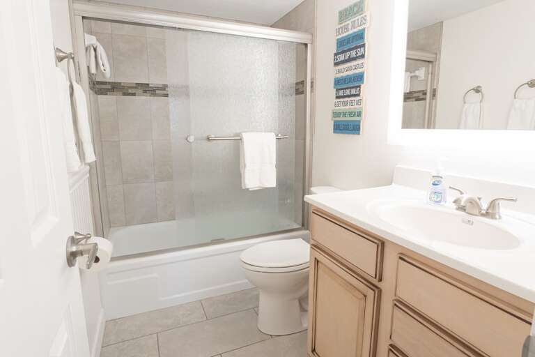 Guest bathroom featuring a convenient tub-shower combo, ideal for a relaxing soak or quick rinse, along with a modern lighted mirror Guest bathroom featuring a convenient tub-shower combo, ideal for a relaxing soak or quick rinse, along with a modern lighted mirror
