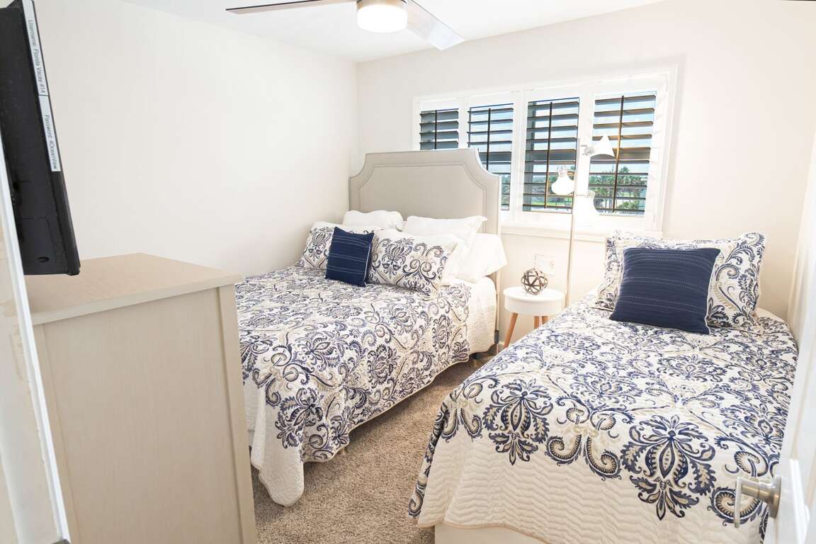 Guest bedroom with a cozy queen bed, twin bed, and a TV, providing a comfortable space for relaxation and entertainment Guest bedroom with a cozy queen bed, twin bed, and a TV, providing a comfortable space for relaxation and entertainment