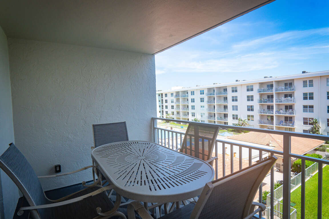 Table with 4 chairs on the 4th-floor balcony, ideal for outdoor dining or enjoying the breeze with a scenic view of the pool deck and ocean Table with 4 chairs on the 4th-floor balcony, ideal for outdoor dining or enjoying the breeze with a scenic view of the pool deck and ocean