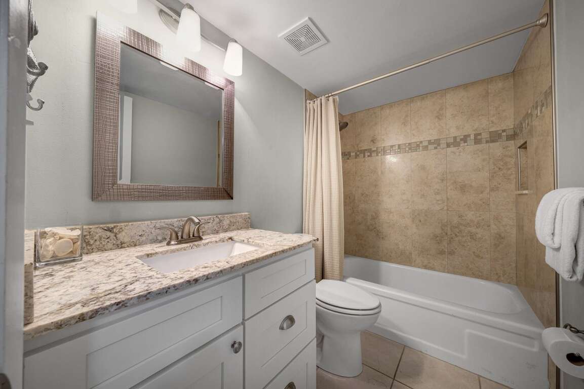 The guest bathroom is equipped with a tub-shower combo and granite counters for a clean, modern feel The guest bathroom is equipped with a tub-shower combo and granite counters for a clean, modern feel