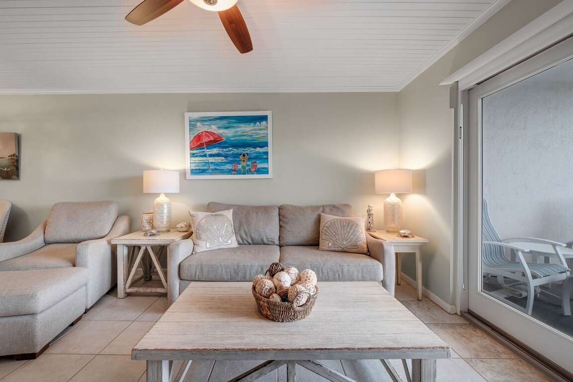 Relax on the comfortable couch and lounge chair in the living room, offering a comfortable setting to enjoy your beach vacation Relax on the comfortable couch and lounge chair in the living room, offering a comfortable setting to enjoy your beach vacation