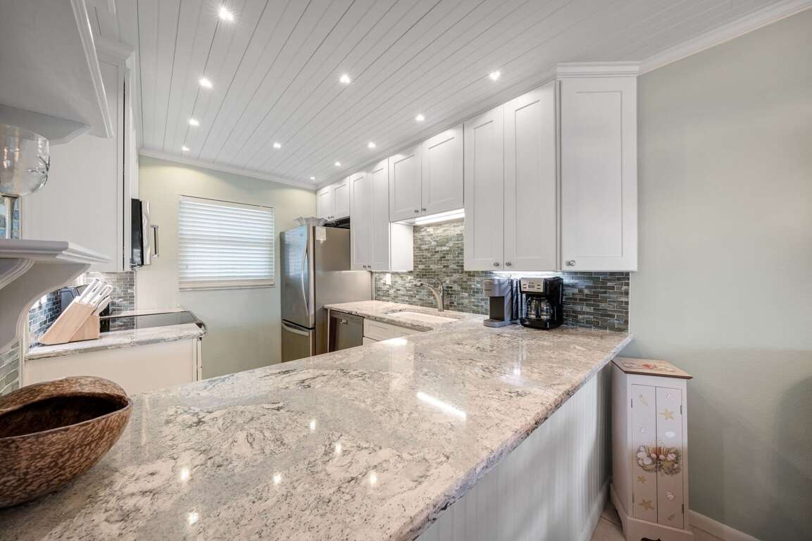 The updated kitchen features elegant granite countertops, providing a stylish and functional space for preparing meals during your beach getaway The updated kitchen features elegant granite countertops, providing a stylish and functional space for preparing meals during your beach getaway