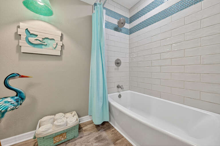 Modern guest bathroom with a stylish shower-tub combo, perfect for relaxation after a day at the beach.