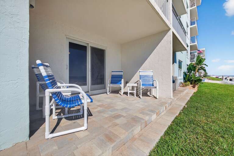 Unwind on the open first-floor patio with comfy seating and direct oceanfront views just steps from the sand.