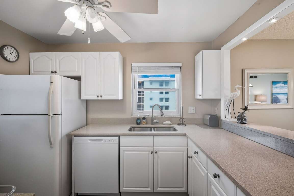 This corner condo features a kitchen with a serene poolside view, blending convenience and tranquility for the perfect beach retreat This corner condo features a kitchen with a serene poolside view, blending convenience and tranquility for the perfect beach retreat