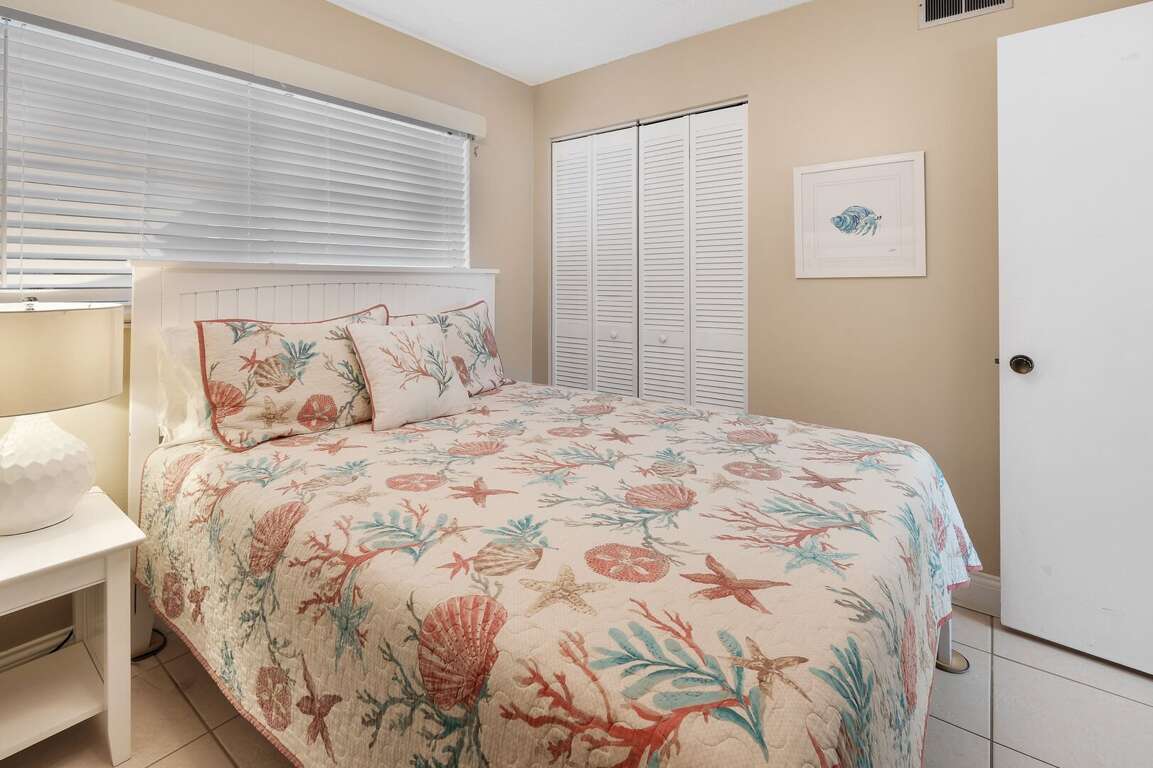 The cozy queen bed in the guest bedroom is perfect for a restful night's sleep after a day at the beach The cozy queen bed in the guest bedroom is perfect for a restful night's sleep after a day at the beach