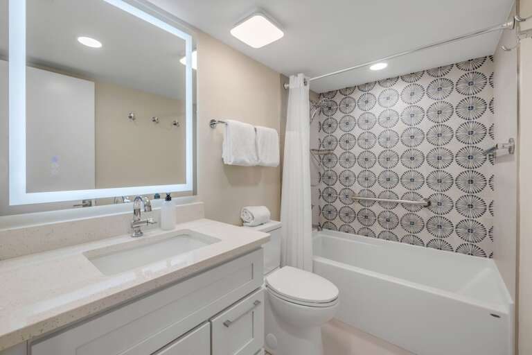 The guest bathroom is equipped with a tub/shower combo