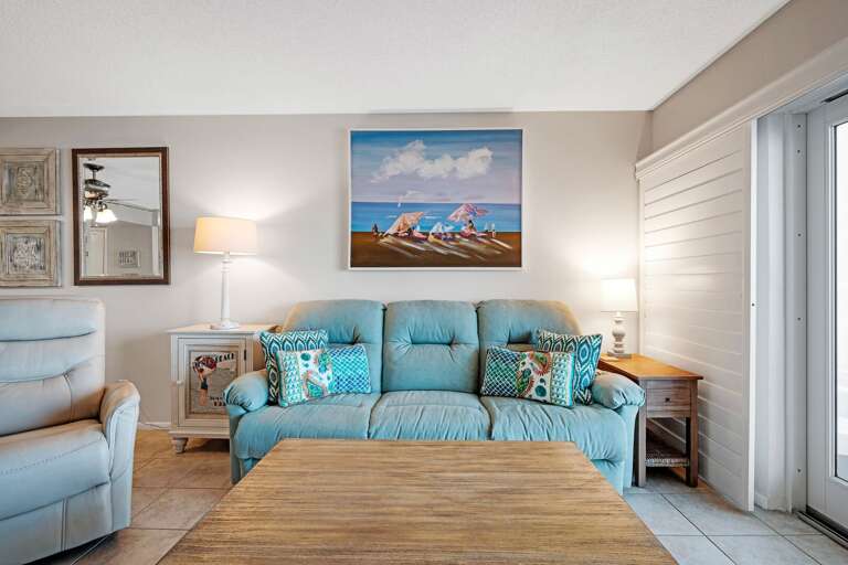 The oceanfront living room features a comfortable couch, ideal for relaxing after a day at the beach The oceanfront living room features a comfortable couch, ideal for relaxing after a day at the beach