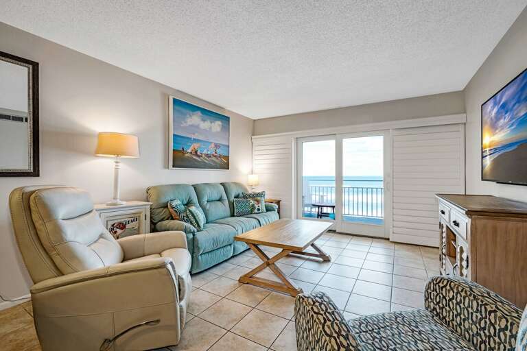 Relax in the direct oceanfront living room, featuring a cozy couch and a recliner for ultimate comfort by the sea Relax in the direct oceanfront living room, featuring a cozy couch and a recliner for ultimate comfort by the sea