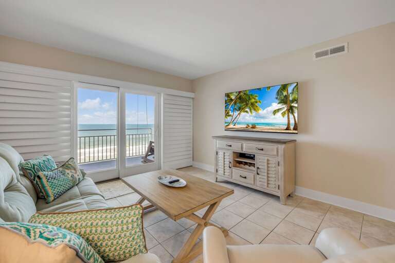 Relax in the direct oceanfront living room, featuring a cozy couch and a recliner for ultimate comfort by the sea