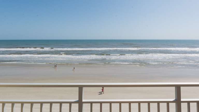 The wide, flat stretch of New Smyrna Beach offers plenty of space for relaxation, water sports, and family fun