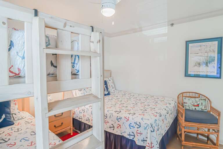 The guest bedroom features a comfortable queen bed and a twin bunk bed, accommodating up to four guests The guest bedroom features a comfortable queen bed and a twin bunk bed, accommodating up to four guests