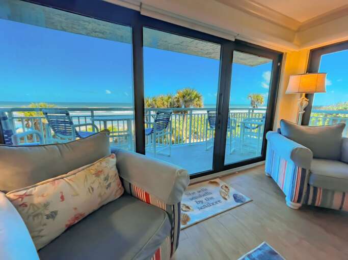 The oceanfront living room features sliding glass doors, offering a gorgeous view of New Smyrna Beach and ocean just outside The oceanfront living room features sliding glass doors, offering a gorgeous view of New Smyrna Beach and ocean just outside