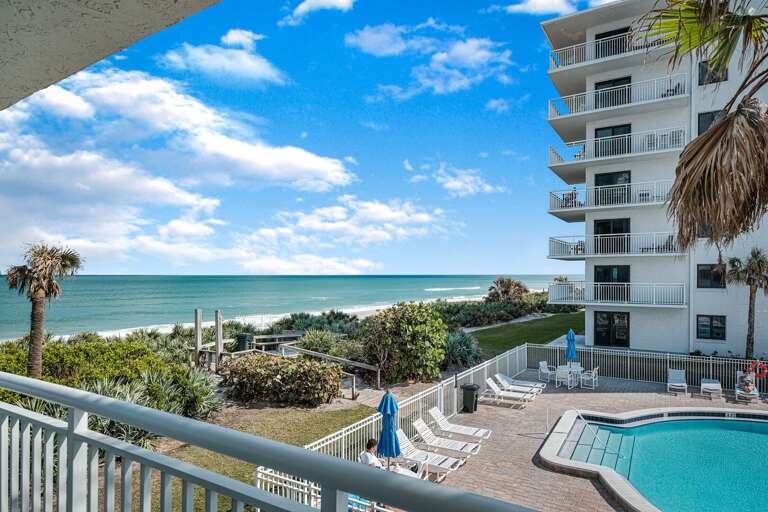 Spacious wrap-around balcony with views of the Atlantic Ocean, New Smyrna Beach, and the Shorehom by the Sea pool