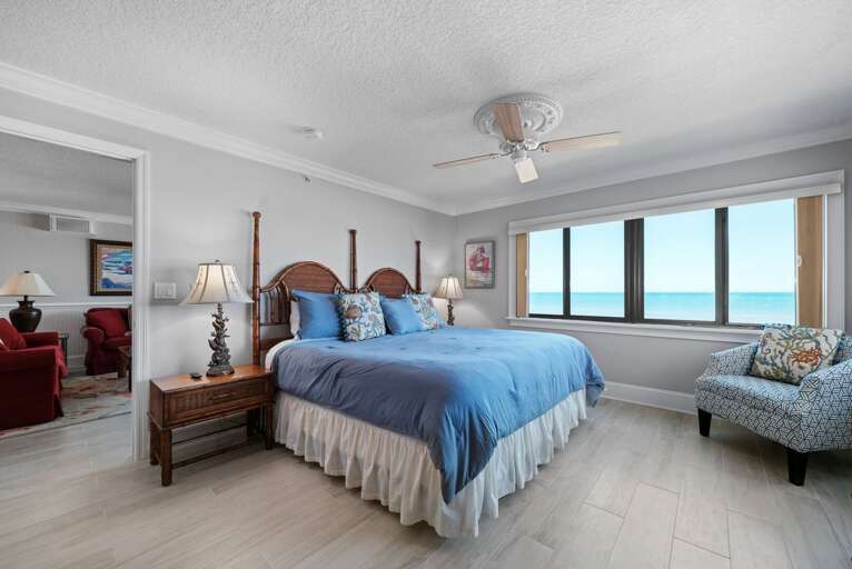 The master bedroom suite includes a king bed with fresh linens, a New Smyrna Beach view, and an ensuite bathroom