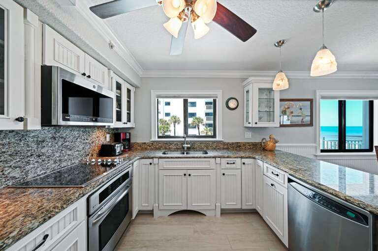 Modern kitchen featuring stainless steel appliances and a picturesque view of the Shorehom by the Sea pool