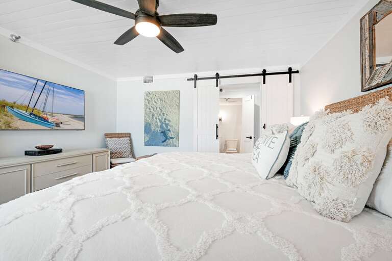 The master bedroom has a mounted TV and an ensuite bathroom